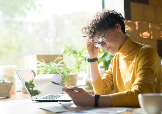 femme qui réfléchi sur son bureau avec tasse de café